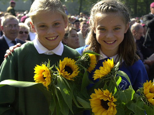 Two children hold sunflowers